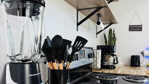 A kitchen with a Hamilton Beach blender, a coffee maker, and a stove.