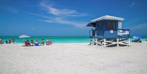 A lifeguard tower on a sandy beach with clear turquoise water. - Private, cozy, beach guest-suite C (Venice)