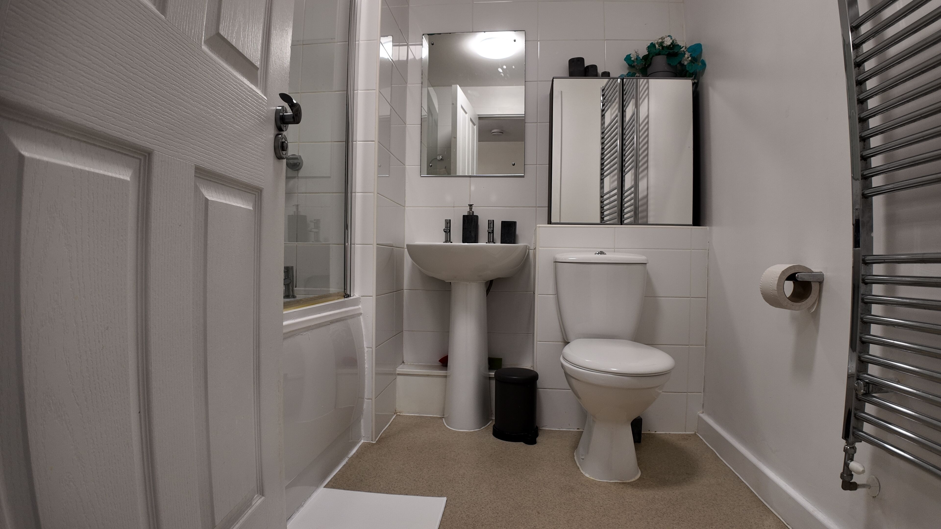 A compact bathroom with a toilet, sink, and a mirror above the sink.