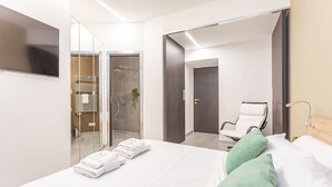 A modern hotel room with a bed, a TV, a shower area, and a seating area. - Vatican Museums Stay with Terrace (Roma)