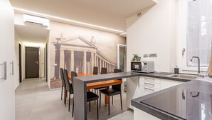 A modern kitchen with a dining area, featuring a marble countertop, a microwave, and a sink. - Vatican Museums Stay with Terrace (Roma)