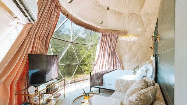 Une pièce spacieuse avec une grande fenêtre, un canapé confortable, un téléviseur et une bibliothèque.