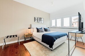 Une chambre moderne avec un lit, une table de chevet, une lampe et un bureau avec une chaise.