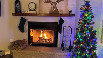 A fireplace with a Christmas tree decorated with colorful lights and ornaments.