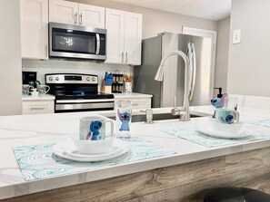 Een magnetron, een oven, een kookplaat, een vaatwasser