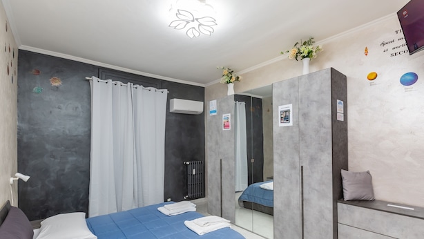Un dormitorio moderno con cama, armario, espejo y cortina de ducha.