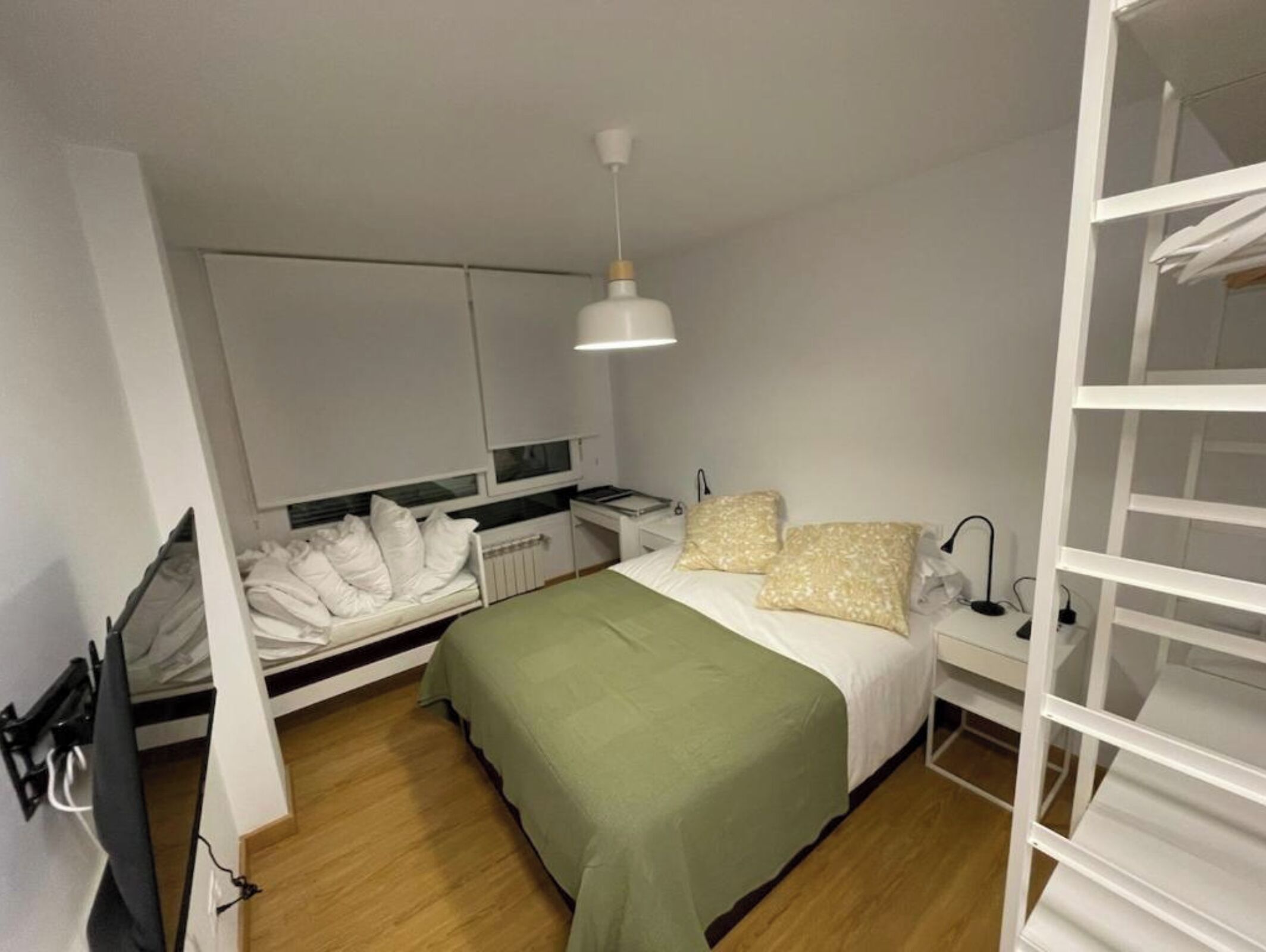 Une chambre à coucher avec un lit, une table de chevet, une lampe et un luminaire suspendu.