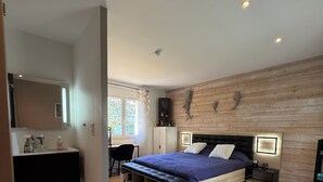 Ein modernes Schlafzimmer mit einem großen Bett, einer Holzwand, einem Schreibtisch und einem Stuhl.