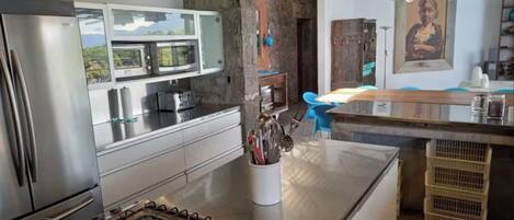A modern kitchen with stainless steel appliances, a gas stove, and a large island with a sink.