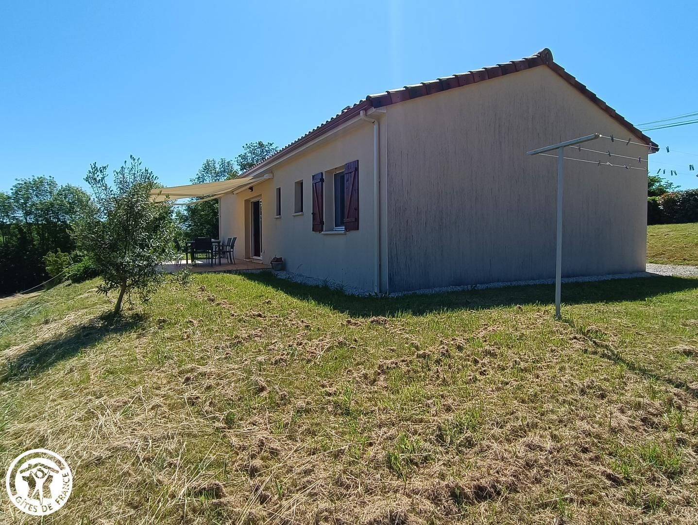 Uma casa térrea com telhado plano, um pequeno alpendre e uma porta.