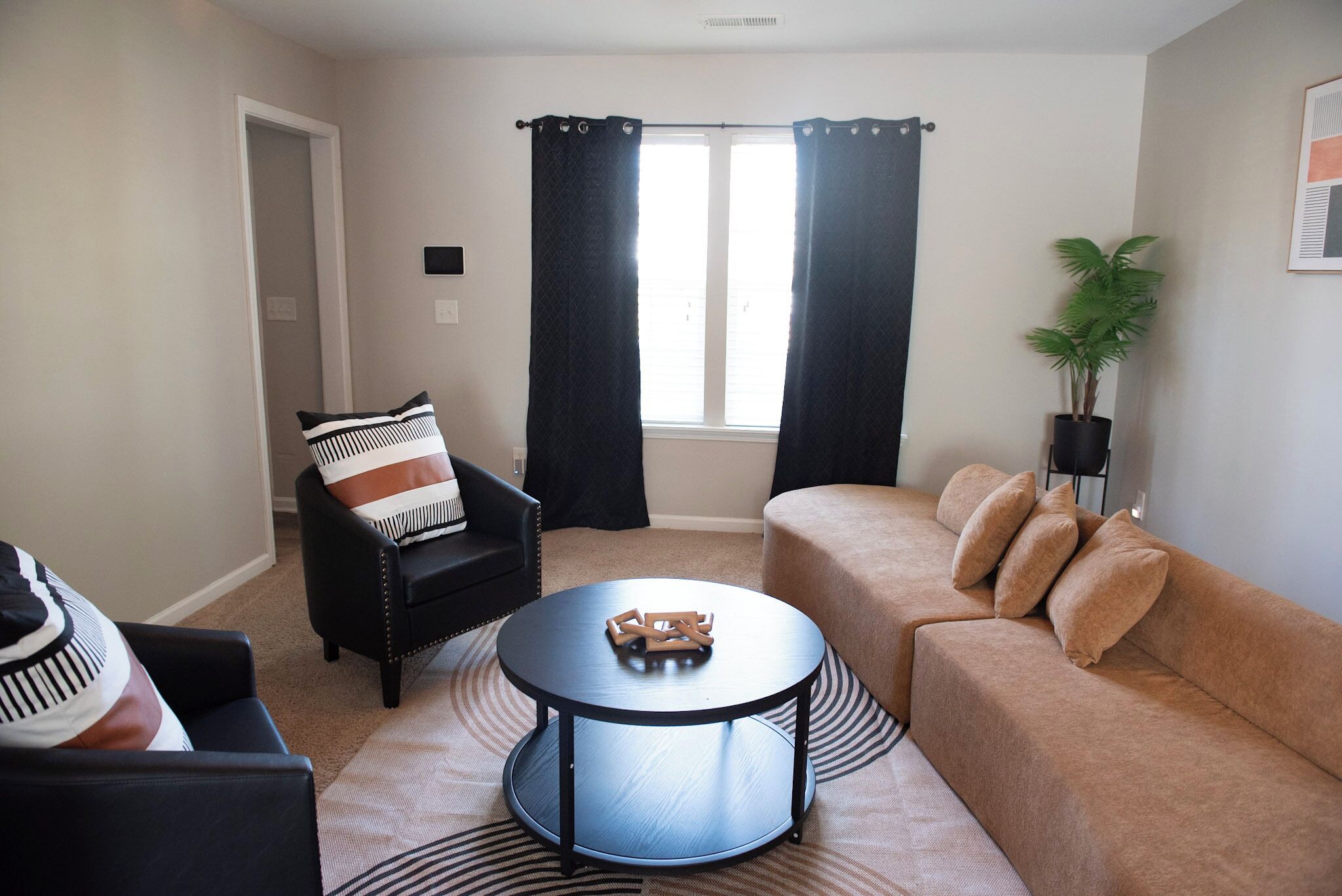 Cozy den featuring a comfortable couch and two decorative chairs.