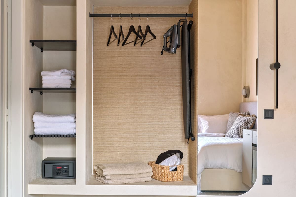 Une salle de bain moderne dotée d’une douche intégrée, d’un porte-serviettes et d’un meuble de rangement contenant des serviettes soigneusement pliées.