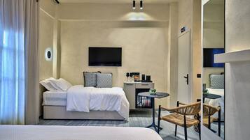 Una habitación de hotel moderna con una cama grande, un escritorio pequeño, un televisor y una silla de mimbre.