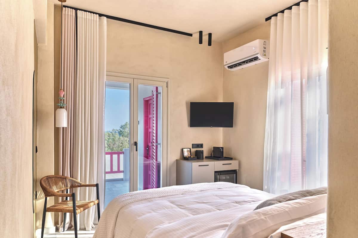 Une chambre comprenant un lit, un bureau, une chaise, un appareil de climatisation et un téléviseur.