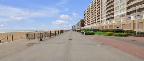 A beachfront promenade with a high-rise hotel.