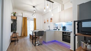Cozinha moderna com ilha central, forno embutido e área de refeições com um banqueta.