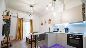 Cozinha moderna com ilha central, forno embutido e iluminação pendente.