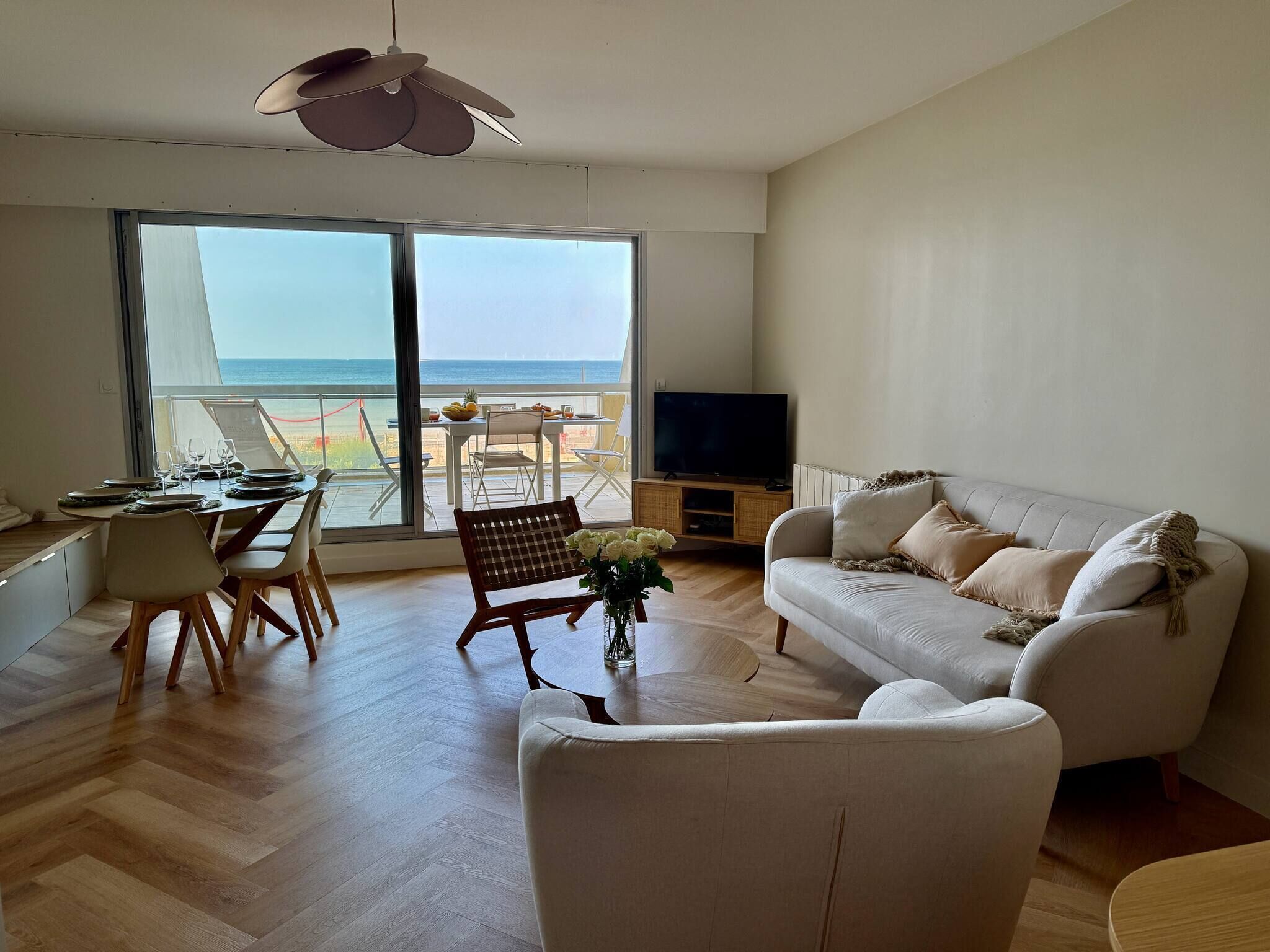 A spacious living area with a balcony, a dining table, and a sofa.