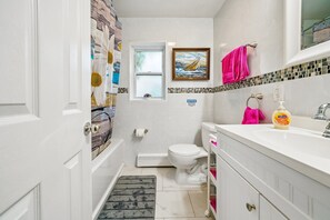 Une petite salle de bain comprenant des toilettes, un lavabo et un espace douche.