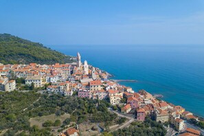 Une ville côtière avec des bâtiments qui bordent la mer, une église imposante et une côte rocheuse.