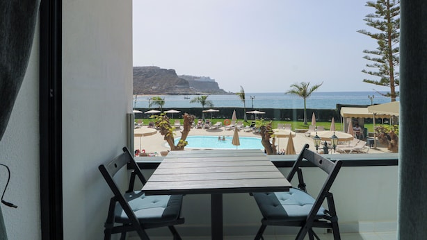 A balcony with a view of a pool and the sea. - Cura Marina Seafront Playa del Cura (Mogán)