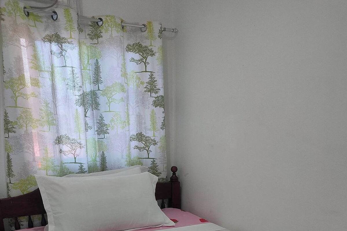 A neatly made bed with a white sheet and a decorative swan towel.