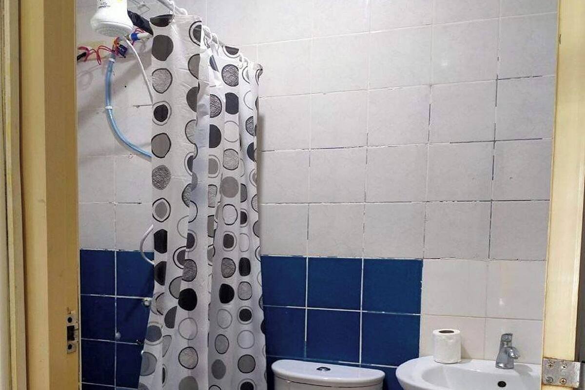 A bathroom with a toilet, sink, and shower curtain.