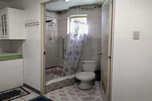 A small bathroom with a toilet, shower, and sink. - Istroberi Inn By Zuzu (Puerto Princesa)