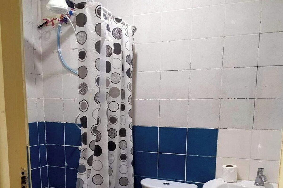 A bathroom with a toilet, sink, and shower curtain.