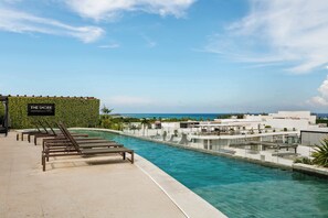 A rooftop pool area with lounge chairs and a sign reading 'THE SHORE AT46'.