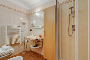 Ein Badezimmer mit Toilette, Waschbecken, Spiegel, Handtuchhalter und Dusche.