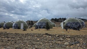 Geodesic dome yurts with outdoor seating and a rocky foreground. - The Nest at Black Hawk (Black Hawk)