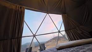 A tent with a view of a mountainous landscape through a geometric window design. - The Nest at Black Hawk (Black Hawk)