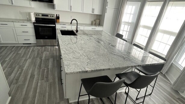 A modern kitchen with a large island, white cabinetry, and a built-in oven. - The peaceful oasis

Charming 3-bedroom house with WiFi, AC in welcoming Carroll (Carroll)