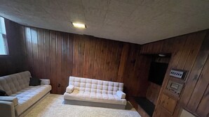 A room with a beige carpet, a white sofa, and wooden paneling on the walls. - The peaceful oasis

Charming 3-bedroom house with WiFi, AC in welcoming Carroll (Carroll)