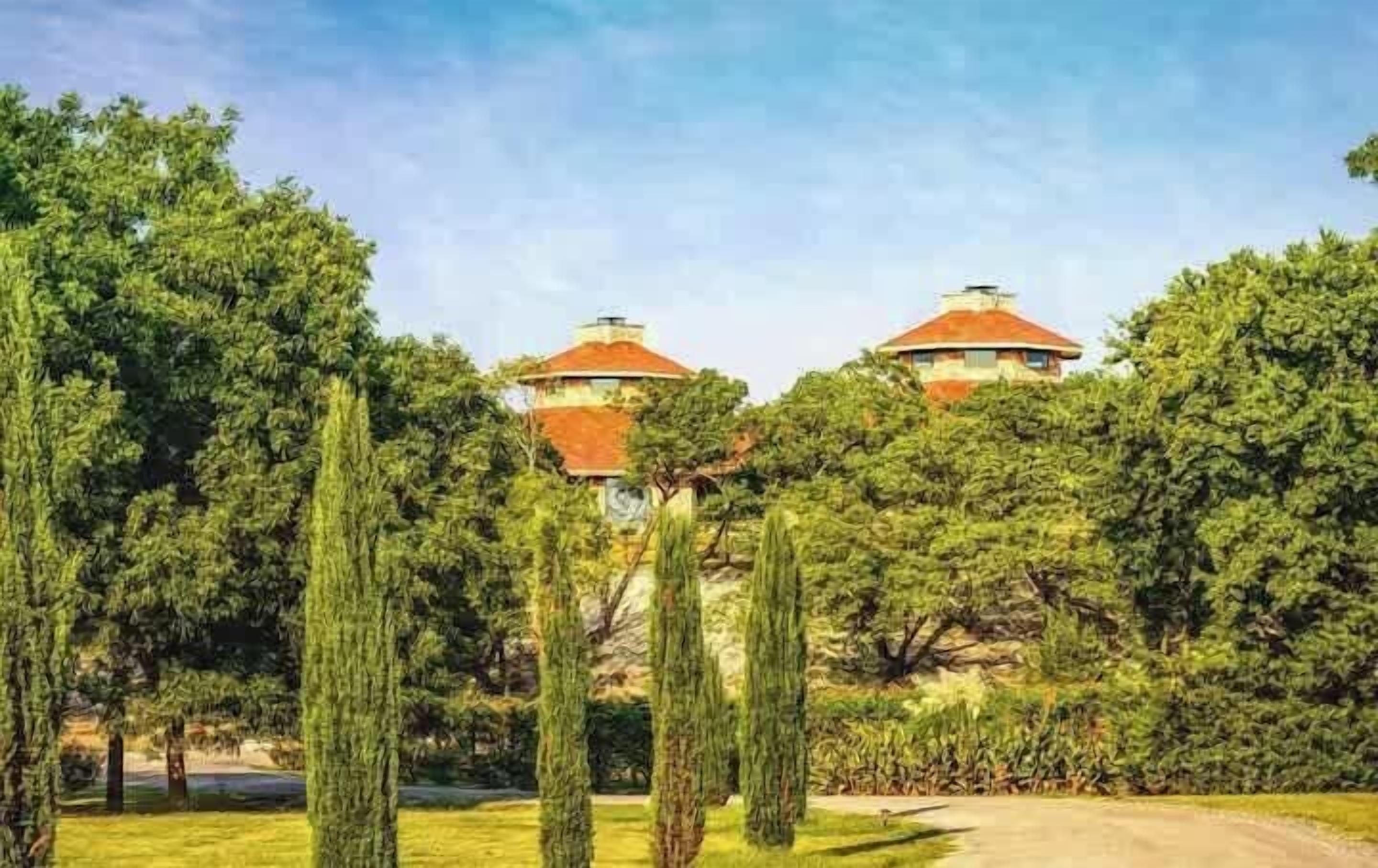 A building with a dome roof surrounded by trees.