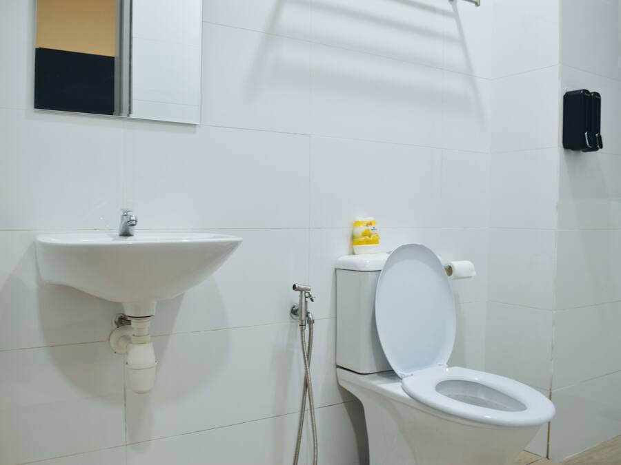 A bathroom with a white sink, toilet, and a mirror.