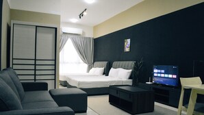 Una habitación de hotel moderna con cama, sofá, televisor y escritorio.