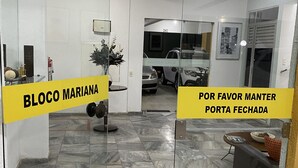A reception area with a marble floor, a reception desk, and a glass partition. - Refúgio das Dunas, perfect for those who collect moments with family/friends. (Capim Macio Natal)