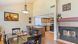 A spacious kitchen with a dining area, featuring a large island, modern appliances, and a fireplace. - Open Two-level/3 bdrm/Sleeps 16/Pools & Hot Tubs/Mini-Golf/Family friendly! (St. George)