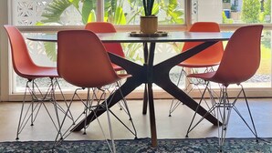 A dining area with a table, chairs, and a hanging light fixture. - Tempe Pool House - Walk to ASU, Midcentury Wonder! (Tempe)