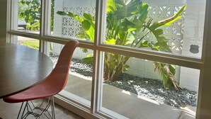A room with a large window, a table, and a chair. - Tempe Pool House - Walk to ASU, Midcentury Wonder! (Tempe)