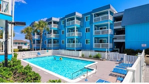A multi-story hotel with a swimming pool and outdoor seating. - Beach House at Garden City. 2-BR condo with private pool, on the beach. (Murrells Inlet)