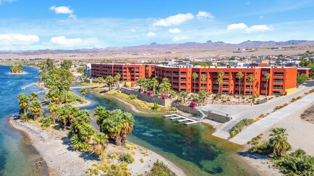 A hotel with a central courtyard, palm trees, and a view of the surrounding desert and mountains. -  3 BDR Riverfront Resort w/pool, spa, dock & launch! (Bullhead City)