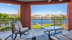 A balcony with a view of a body of water, a distant cityscape, and a mountain range. -  3 BDR Riverfront Resort w/pool, spa, dock & launch! (Bullhead City)