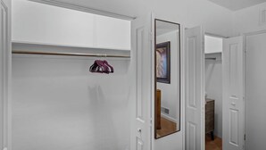 A hallway with a coat rack, a mirror, and a door leading to another room. - Centrally located home in the heart of Tucson (Tucson)