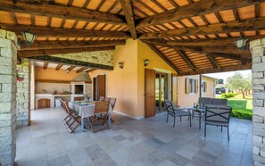 An outdoor patio with stone walls, wooden beams, and a tiled floor. - Villa Oliveta (Istria - Filipana) (Filipana)