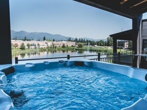 A hot tub with a view of a lake and mountains. - New! Condo w hot tub, close to Downtown & Glacier National Park (Whitefish)