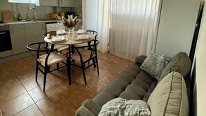 Ein gemütlicher Wohnraum mit Essbereich, einer Couch und einer Küche.