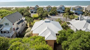 A coastal residential area with houses, a beach, and a clear sky.